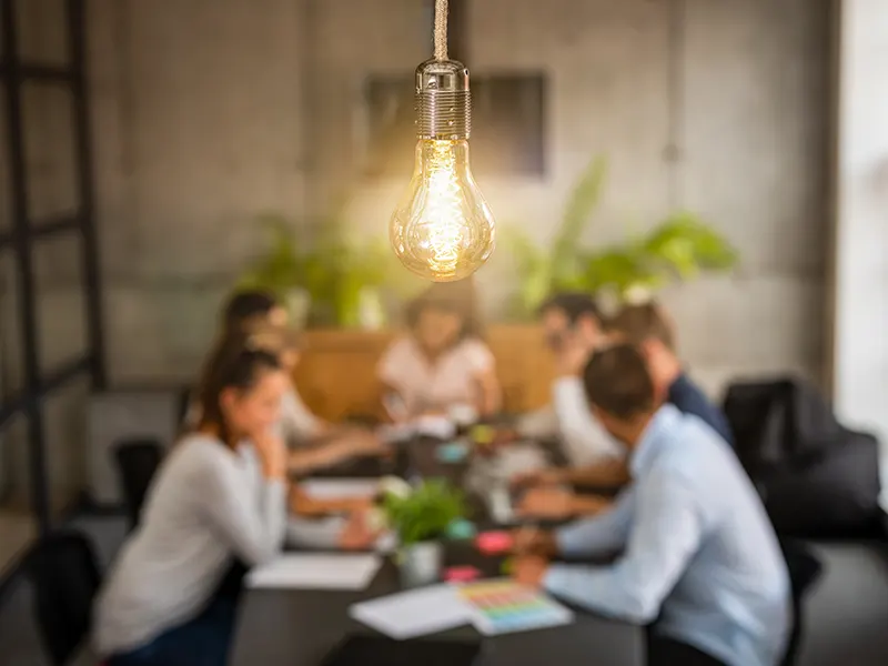 Image of team members meeting round a table